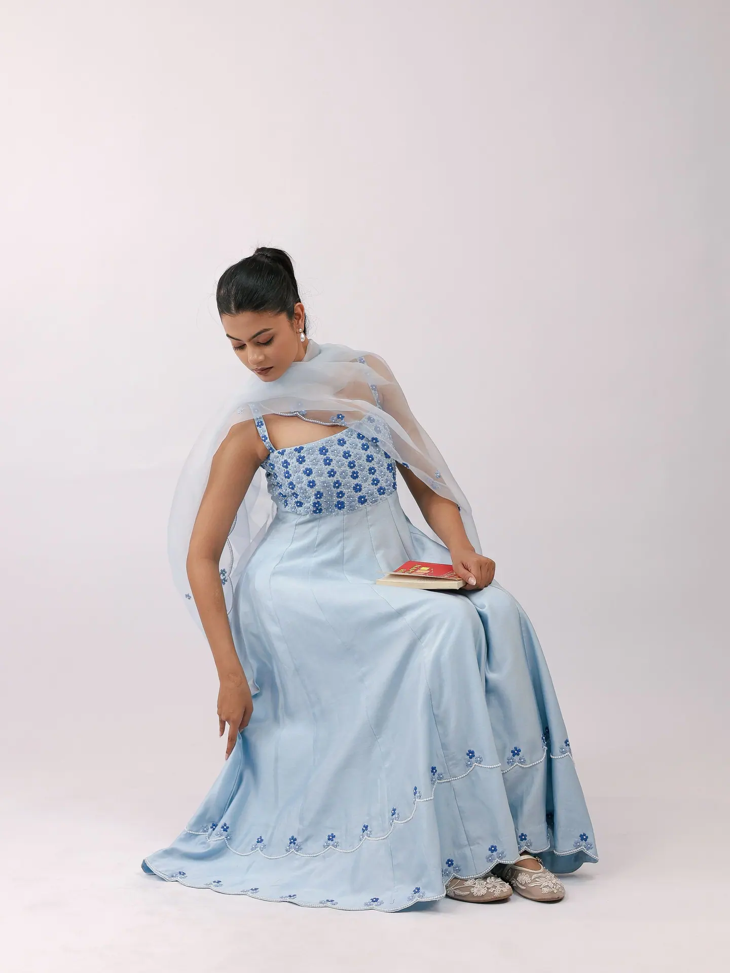 Model seated in the powder-blue anarkali