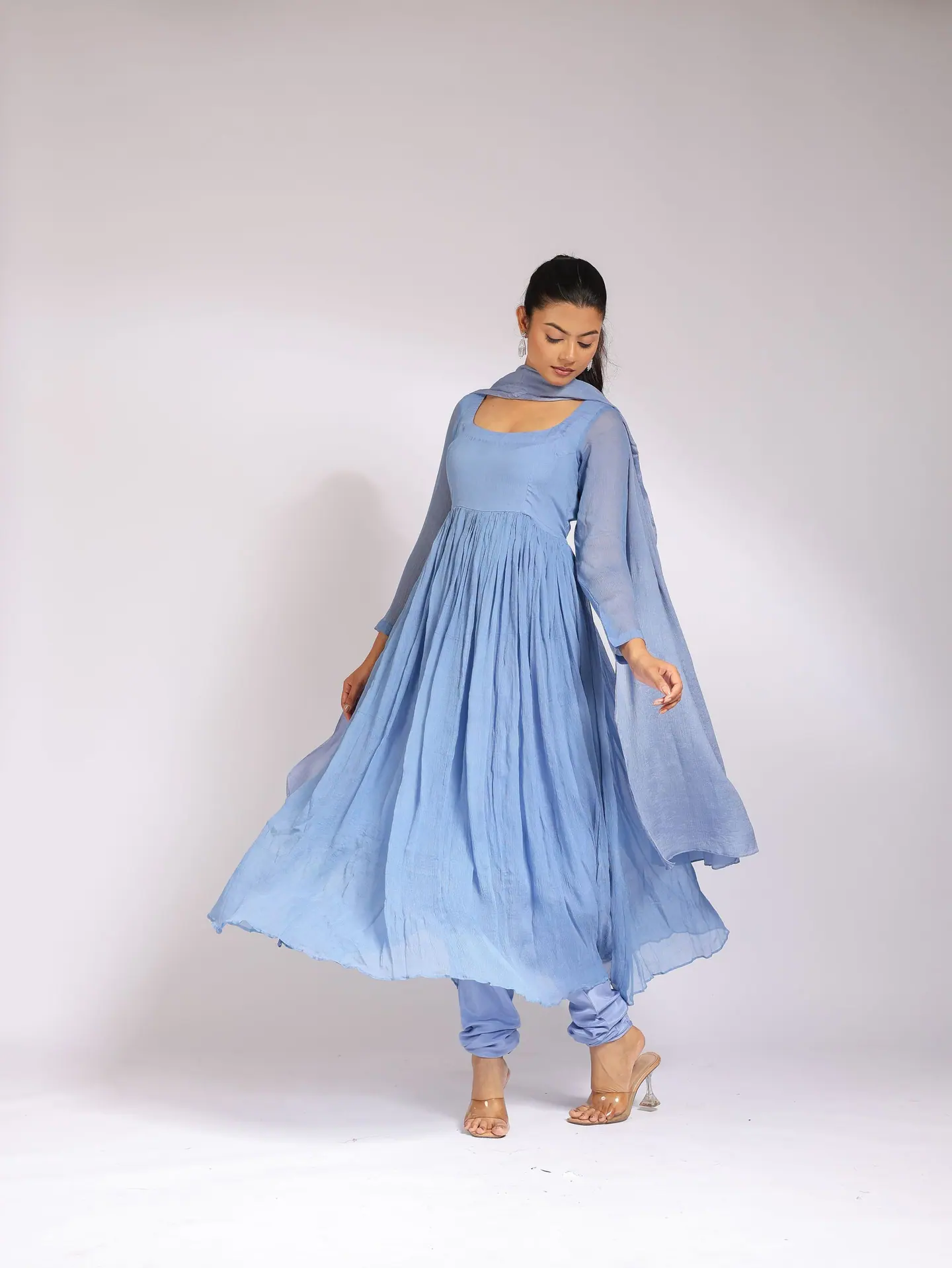 Cornflower-blue anarkali flaring mid-twirl, with dupatta